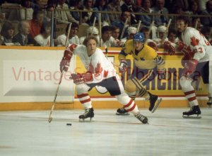 Picking up a drop-pass from Larry Robinson, Bobby Hull #9 crosses the line down the right, while Sweden's wing Kjell-Arne Wikström�s receding into the background. Hull's the man with the puck! The man in control! He looks to his left, fancies his chances and spots a linemate. Danger brewing on Sweden! The crowd is roaring and jumping out of their seats! Go Canada!