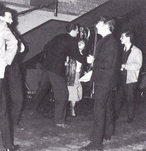 1 July 1963, inside EMI Studios. Their July session dates having been publicised in advance by the weekly pop papers, police twice had to be summoned to Abbey Road when the Beatles came to record, so many were the fans outside. One girl managed to penetrate studio two before the She Loves You session, almost reaching John (seen here chatting to balance engineer Norman Smith.)