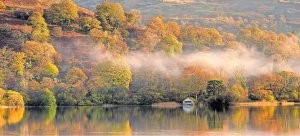 The autumnal colours and their reflection in the calm surface of Cumbrias Rydal Water, near Ambleside in the Lake District by Vagner Vidal