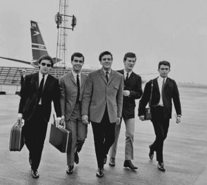   * English singer Billy J. Kramer and his backing band the Dakotas arrive back at London Airport, after their US tour, 22nd June 1964. 