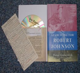 ERIC CLAPTON Me And Mr Johnson Sampler (2004 US 4-track promo album sampler CD, contained in a library book style custom card picture wallet affixed to the inside of a US 86-page paperback biography of Robert Johnson, written by Peter Guralnick, and complete with library book card with facsimile autographs of other artists influenced by Robert Johnson - tracks are When You Got A Good Friend, Come On In My Kitchen, Milkcow's Calf Blues and If I Had Possession Over Judgement Day)