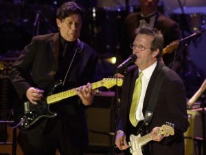 Rock and Roll Hall of Fame inductee Eric Clapton, right, sings with guitarist Robbie Robertson, left, during induction ceremonies at the Waldorf-Astoria Hotel in New York on March 6, 2000. Robertson introduced Clapton.